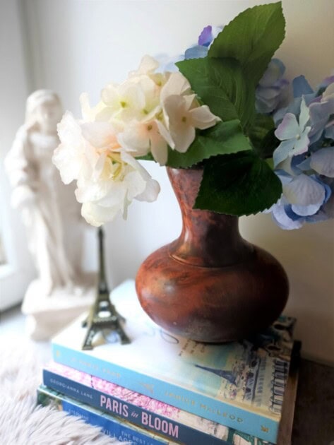 A vase of flowers with a Parisian Eiffel tower figurine